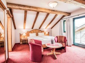 Schlafzimmer mit einem Bett, einem Tisch und Stühlen in der Unterkunft Hotel Elisabeth, 4 Sterne Superior in Kirchberg in Tirol
