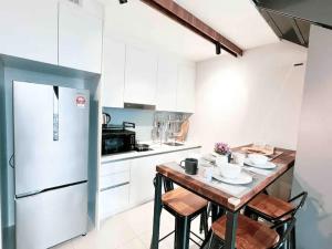 a kitchen with a table with chairs and a refrigerator at EkoCheras Cozy Suite by GUESTONIC in Kuala Lumpur