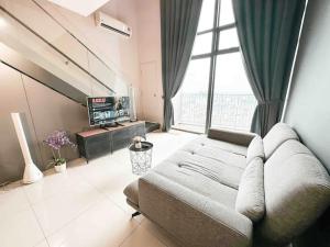 uma sala de estar com um sofá e uma grande janela em EkoCheras Cozy Suite by GUESTONIC em Kuala Lumpur