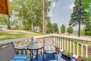 a patio with a table and chairs on a balcony at Charming Michigan Cottage with Sunroom and Lake Access in Hubbard Lake