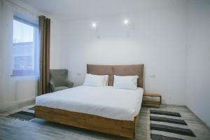 a bedroom with a large bed with white sheets and a window at Dominion Relax Club in Shaian