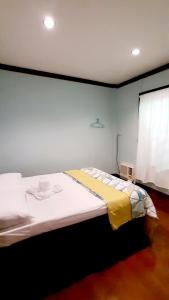 sypialnia z dużym łóżkiem i żółtym kocem w obiekcie Pinaluyan Guest House w mieście Puerto Princesa