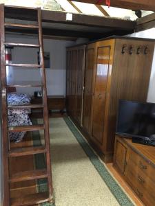 a room with a bunk bed and a ladder and a television at Etno selo Krugerdorf 
