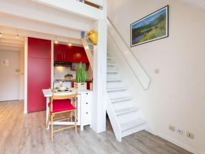 a room with a staircase and a table and a kitchen at Charmant appart. 4 pers. près de Saint Lary avec navette gratuite et forfaits ski! - FR-1-296-327 in Vielle-Aure