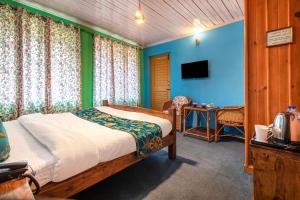 a bedroom with a bed and a table and a television at Hotel Little Silver in Pahalgām