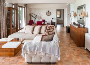 a living room with a couch and a table at Luxury Villa Hera - Beachfront in Roda