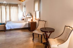 a bedroom with a bed and a table and chairs at Luxury Villa Hera - Beachfront in Roda +13 photos