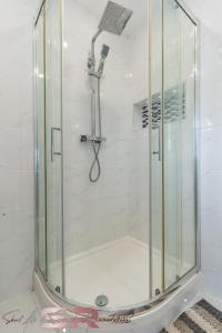 a shower with a glass door in a bathroom at Rush House by SR Short Lets & Serviced Accommodation Heathrow Windsor - Perfect for Monthly Stay Relocation & Business Contractors Big Groups in Northolt