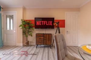 a living room with a netflix sign on the wall at Rush House by SR Short Lets & Serviced Accommodation Heathrow Windsor - Perfect for Monthly Stay Relocation & Business Contractors Big Groups in Northolt