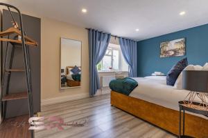 a bedroom with a bed with blue walls and a ladder at Rush House by SR Short Lets & Serviced Accommodation Heathrow Windsor - Perfect for Monthly Stay Relocation & Business Contractors Big Groups in Northolt