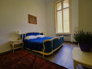 a bedroom with a blue bed and a window at Herrnhof in Reichenau