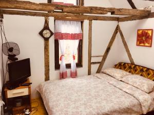 1 dormitorio con 1 cama y reloj en la pared en Etno selo Krugerdorf 