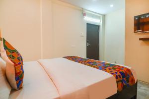 um quarto com uma cama com um cobertor colorido em FabHotel Lotus Park em Visakhapatnam