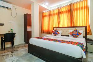um quarto com uma cama, uma secretária e uma cadeira em FabHotel Lotus Park em Visakhapatnam