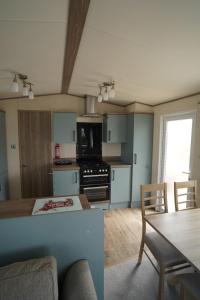 uma cozinha e sala de estar com mesa e cadeiras em Heacham Sunset lodge Platinum van em Hunstanton