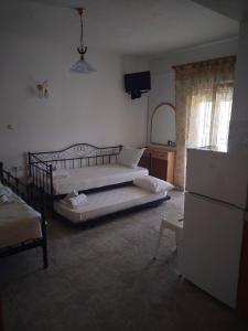 a bedroom with two beds and a refrigerator at Vigla House in Sykia Chalkidikis