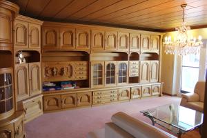 a living room with wooden cabinets and a chandelier at Ferienwohnungen am Playmobilpark in Oberasbach