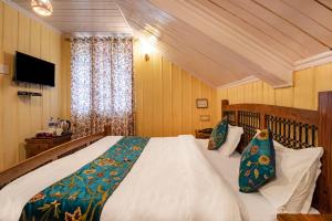 a bedroom with a large bed and a television at Hotel Little Silver in Pahalgām