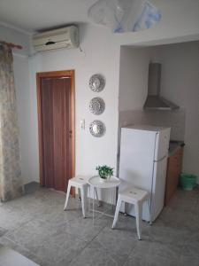 a kitchen with a table and a white refrigerator at Vigla House in Sykia Chalkidikis