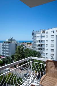 einen Balkon mit 2 Stühlen und einigen Gebäuden in der Unterkunft Lara Dinc Hotel in Antalya