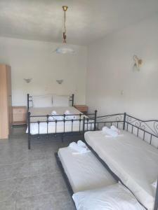 two twin beds in a room with white sheets at Vigla House in Sykia Chalkidikis