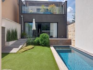 une maison avec une piscine en face d'une maison dans l'établissement Le Clos des Jardins, à Dijon
