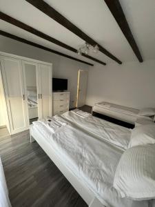 um quarto com uma grande cama branca e uma televisão em House Of Beyoutiful Bocsa em Bocşa