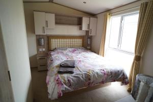 a bedroom with a bed and a window at Heacham Sunset lodge Platinum van in Hunstanton