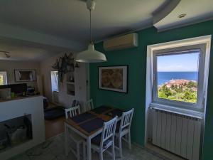 a dining room with a table and a window at Captain's Cabin Piran - free parking in Piran
