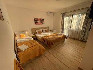 1 dormitorio con 2 camas y ventana en Vila Lorena, en Mangalia