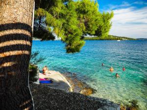 um grupo de pessoas na água em uma praia em Salve Croatia Mobile Homes in Amadria Park Trogir em Seget Vranjica