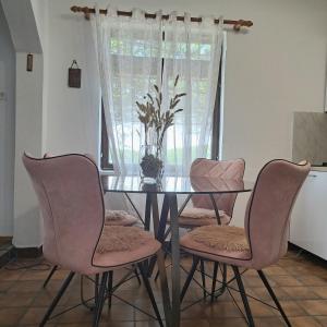 a dining room table with four chairs and a vase on it at Guest House Tanja in Babino Polje