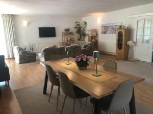 a living room with a wooden table and chairs at Dom Natura in Grzybowo