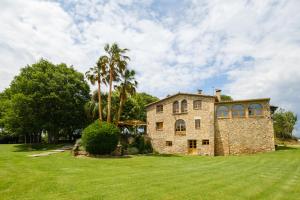 una grande casa in pietra con palme in un campo di Mas Cufí a Serinyà