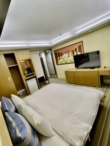 um quarto com uma cama e uma secretária com um computador portátil em Morn Sun Hotel em Changhua County