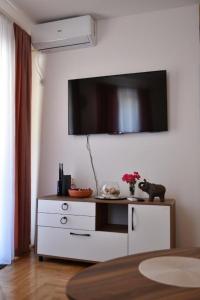 a white dresser with a television on a wall at Apartment Dimitrije in Budva