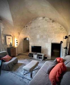 ein großes Wohnzimmer mit einer Steinmauer in der Unterkunft Au pays de Gide appart feutré dans un château in Lussan
