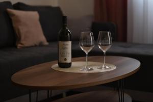 a bottle of wine and two wine glasses on a table at Apartment Dimitrije in Budva