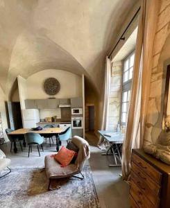 eine Küche und ein Esszimmer mit einem Tisch und Stühlen in der Unterkunft Au pays de Gide appart feutré dans un château in Lussan