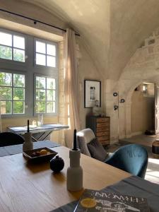 ein Wohnzimmer mit einem Holztisch im Zimmer in der Unterkunft Au pays de Gide appart feutré dans un château in Lussan