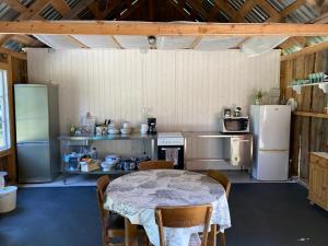 a kitchen with a table with chairs and refrigerator at Suurkivi Nature Escape in Häädemeeste