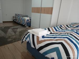 Grand Apartments Strumica في ستروميكا: سريرين في غرفة مع روحانية مذهب مسيحي