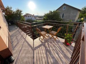 a deck with a table and chairs on a balcony at Vila Lorena in Mangalia