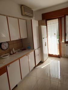 a kitchen with white cabinets and a refrigerator at Viale Unità D'Italia in Formia +5 photos