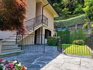 ein Tor zu einem Haus mit Treppen und Blumen in der Unterkunft Le Grigne Guest House in Oliveto Lario