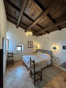 een slaapkamer met een groot bed en een houten plafond bij La Taberna di Rocca Calascio in Calascio