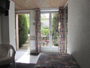 Schlafzimmer mit einer Tür, die auf eine Terrasse führt in der Unterkunft Auberge de l'Arzon in Chomelix