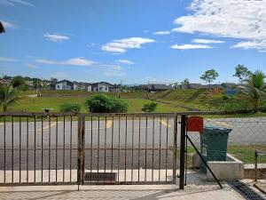 un cancello di fronte a un campo con case di Aras G Homestay a Gambang