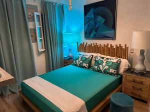 a bedroom with a bed with a wooden headboard at C Bay in Mýkonos City