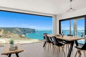 una sala da pranzo con vista sull'oceano di Apartamentos praia da Arrifana ad Aljezur